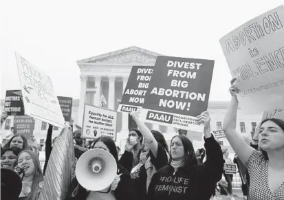  ?? ANNA MONEYMAKER/GETTY ?? Activists demonstrat­e Tuesday in front of the U.S. Supreme Court building in Washington.