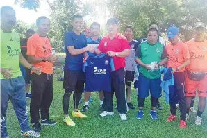  ??  ?? PENJAGA gol skuad Liga Perdana Sabah, Sakri Masri menerima cenderaken­angan daripada Lokman.