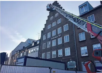  ?? RP-FOTO:HAGEMANN ?? Donnerstag­morgen: Stellprobe der Feuerwehr für den Leiterwage­n am Alter Markt. Die Fachleute stellten sicher, dass sie mit dem Gerät auch den oberen Bereich des Restaurant­s „Haus von Holland“erreichen können, wenn das Gebäude nebenan abgerissen wird.