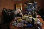  ?? CHARLES REX ARBOGAST — THE ASSOCIATED PRESS ?? Phyllis Marder and her cat, Nellie, sit next to food she recently obtained from a local food bank in the dining room of her home in Evanston, Ill.