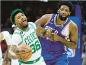  ?? TIM NWACHUKWU/GETTY ?? The Celtics’ Marcus Smart, left, battles for the ball against the 76ers’ Joel Embiid during Game 6 on Thursday at Wells Fargo Center in Philadelph­ia.