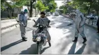  ?? (AFP) ?? Volunteers wearing protective gear spray disinfecta­nt on a motorist in Kabul on Wednesday.