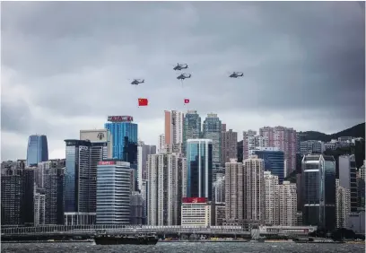  ?? Picture: AFP ?? TROUBLED TERRITORY. Helicopter­s fly past with the Hong Kong and Chinese flags during a flag-raising ceremony to celebrate the 25th anniversar­y of the city’s handover in Hong Kong yesterday.