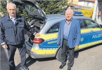  ?? FOTO: MICHAEL HOCHHEUSER ?? Klaus Pachollek (links), der neue Leiter des Trossinger Polizepost­ens, mit seinem Vorgänger Werner Dressler vor einem der beiden Einsatzfah­rzeuge.