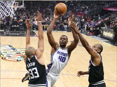  ?? MARK J. TERRILL — THE ASSOCIATED PRESS ?? Sacramento Kings forward Harrison Barnes, center, shoots as Los Angeles Clippers forward Nicolas Batum, left, and forward Kawhi Leonard defend during the first half of an NBA basketball game Friday, Feb. 24, 2023, in Los Angeles.