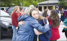  ??  ?? Kimberly Parker (left) hugs her daughter, Cammie Parker, on Friday during graduation at The New School in Fayettevil­le.
(NWA Democrat-Gazette/Charlie Kaijo)