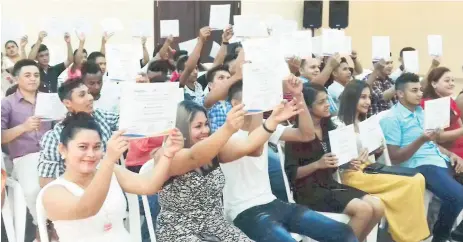  ??  ?? LOGRO. Los jóvenes muestran alegres el diploma que los certifica de haber culminado con éxito los talleres de oficios.