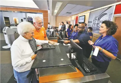  ?? STAFF PHOTO BY DAN HENRY ?? Lenora Yarbrough, left, and her son, Richard Yarbrough, check in to United Airlines' first nonstop flight to the New York area on Wednesday.