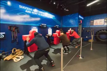  ??  ?? In this undated photo provided by NFL Experience Times Square, participan­ts use football practice equipment installed at NFL Experience Times Square in New York. The $30 million project has taken 2 1/2 years to develop and has something for kids, teens...