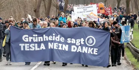  ?? — AFP photos ?? Demonstrat­ors hold a banner reading ‘Gruenheide says Tesla No Thanks’ during a protest against the expansion plan for Tesla’s electric car plant, the company’s only European production site, near the plant in Gruenheide, east of the German capital Berlin.