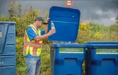  ?? Post-Gazette ?? Ron Liscio Jr. throws a bottle into recycling bins in September 2018 at the White Oak Park office in White Oak.