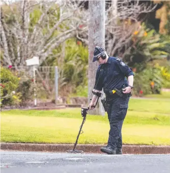  ?? Picture: Kevin Farmer ?? MANHUNT CONTINUES: A forensic officer uses a metal detector to find bullet fragments after a man allegedly exchanged fire with police in Harristown.