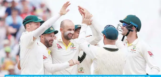  ??  ?? BIRMINGHAM: Australia’s Nathan Lyon (C) celebrates after taking the wicket of England’s Stuart Broad during play on the fifth day of the first Ashes cricket Test match between England and Australia at Edgbaston.