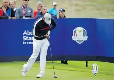  ??  ?? Tiger Woods grimaces in pain after hitting a shot off the sixth tee during the best ball matches Friday at the 42nd Ryder Cup and did not play in the afternoon session, although U.S. captain Jim Furyk says he is fine.