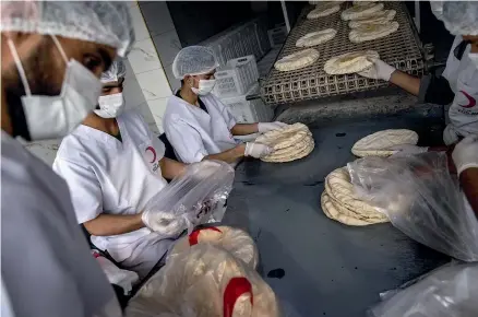  ?? GETTY IMAGES ?? Turkish Red Crescent employees make bread for aid packages in Syria’s Idlib province, whose population has swelled during Syria’s 10-year civil war. Humanitari­an aid groups are praising a United Nations Security Council resolution exempting aid from UN sanctions regimes.
