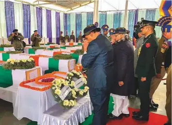  ?? PTI ?? Union Home Minister Rajnath Singh and J &amp; K Governor Satya Pal Malik pay tribute to the CRPF personnel killed in Thursday’s Pulwama terror attack, at the CRPF camp in Budgam, yesterday.