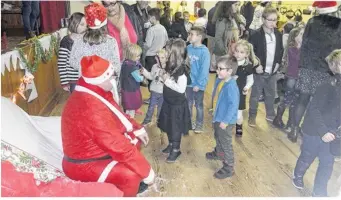  ??  ?? Le Père Noël, figure emblématiq­ue des festivités de fin d’année, attendait les enfants.