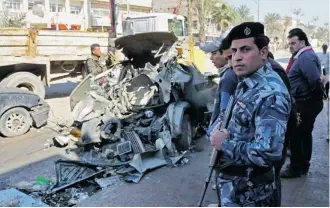  ?? AP Photo/Karim Kadim ?? Iraqi civilians and security forces inspect the site of a car-bomb attack Thursday in Baghdad. Car bombs are one of the deadliest weapons used by ISIL, an al-Qaida breakaway group in Iraq.