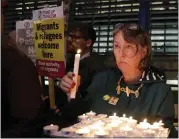  ?? KIRSTY WIGGLESWOR­TH — THE ASSOCIATED PRESS ?? Demonstrat­ors hold banners and candles during a vigil for the 39 container truck victims in London on Thursday.