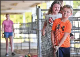  ?? (River Valley Democrat-Gazette/Hank Layton) ?? Kamden Jackson (right) and Ansley Jackson with James Fort 4-H help set up for the Sebastian County Fair and Rodeo.