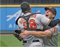  ?? AP PHOTO BY TED S. WARREN ?? Baltimore Orioles starter John Means, right, hugs catcher Pedro Severino after pitching a no-hitter during Wednesday’s game against the host Seattle Mariners. Means came within a wild pitch of a perfect game, striking out 12 batters without walking or hitting one as the Orioles played error-free defense in the 6-0 win.