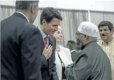  ?? LIAM RICHARDS/THE CANADIAN PRESS ?? Prime Minster Justin Trudeau, centre, shakes hands with Imam Sheikh Ilya Sidyot during Eid al-Adha at Prairielan­d Park in Saskatoon, Friday.