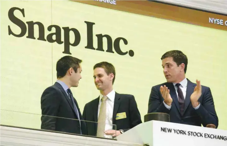  ??  ?? NEW YORK: Snapchat co-founders Bobby Murphy (left) and CEO Evan Spiegel (center) ring the opening bell at the New York Stock Exchange as the company celebrates its IPO on Thursday. — AP