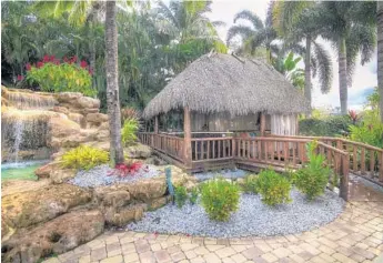  ?? MLS REAL ESTATE/COURTESY ?? A Tahitian hut-style pavilion with a full bar, a 60-inch television, an outdoor kitchen and a nearby koi pond dominates the outdoor entertainm­ent area.