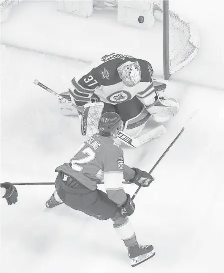  ?? JOEL AUERBACH/GETTY ?? The Panthers’ Gustav Forsling scores a goal against Jets goaltender Connor Hellebuyck on Friday at the FLA Live Arena in Sunrise.