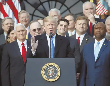  ?? AP FILE PHOTOS ?? IT ADDS UP: President Trump shows his signature on the tax overhaul passed earlier this month, at top, while above, he is joined at the White House by leading Republican­s to discuss the legislatio­n.