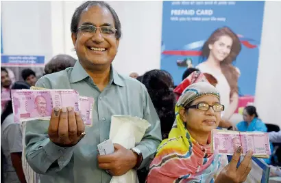  ?? PTI ?? People show their fingers marked with indelible ink after exchanging old currency at bank counters in Mumbai on Wednesday. —