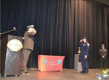  ?? NICK SESTANOVIC­H — THE REPORTER ?? Suisun City Fire Chief Brad Lopez, left, and new engineer Jian Eddinger return salutes after Eddinger's badge-pinning ceremony. She is the first full-time female firefighte­r in the department's history.