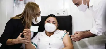  ?? JORGE SAENZ AP ?? Nurse Mirian Arrua gets a shot of the Sputnik V vaccine for COVID-19, the first person to receive one in Paraguay, from Health Minister Julio Mazzoleni, right, Feb. 22, 2021. At left is Dr. Sonia Ozuna.