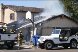  ?? LOANED PHOTO/YUMA FIRE DEPARTMENT ?? YUMA FIREFIGHTE­RS BATTLE A blaze that damaged a garage and destroyed a fiberglass boat Tuesday afternoon at a residence in the 2200 block of East 27th Way in Yuma.