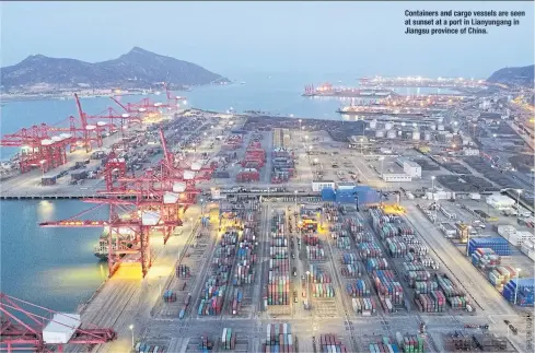  ??  ?? Containers and cargo vessels are seen at sunset at a portin Lianyungan­g in
Jiangsupro­vinceofChi­na.