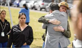  ?? DAVID ZALUBOWSKI / ASSOCIATED PRESS ?? A student (right) hugs a parent as they are reunited following a shooting at East High School, Wednesday in Denver.