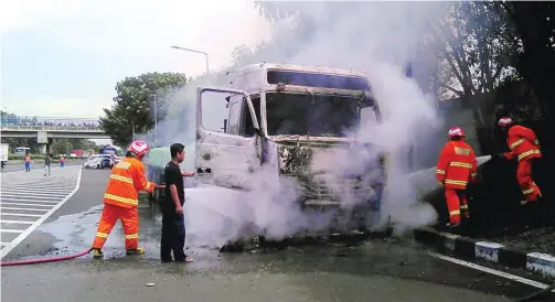  ?? UPT DAMKAR GRESIK FOR JAWA POS ?? DIDUGA KORSLETING: Petugas memadamkan api yang melahap truk trailer bermuatan baja di ruas tol Surabaya–Kebomas, Desa Kadanyang, Kebomas, kemarin.