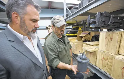  ?? DAILY PRESS FILE ?? Left, Threat Tec President and CEO Jim Crawford and company weapons specialist Gethyn D. Jones show a simulation Russian mine.