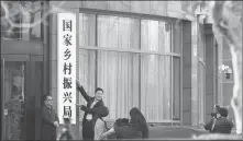  ?? JIANG QIMING / CHINA NEWS SERVICE ?? Government workers take photos with the plaque of the National Administra­tion of Rural Revitaliza­tion following its inaugurati­on in Beijing on Thursday.