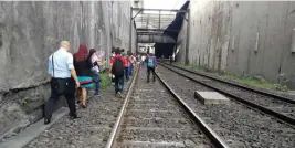  ??  ?? LAKAD PA MORE Sa kuhang ito ni Ivan Caballero Villegas, pasahero ng MRT-3, makikitang napilitang maglakad sa riles ang kapwa niya mga pasahero patungong Ayala Station makaraang kumalas ang kinalulula­nan nilang bagon sa tren nito sa pagitan ng Buendia...