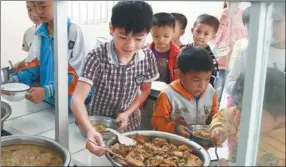  ?? LU PO’AN / XINHUA ?? Students enjoy lunch at Renliang primary school in Dahua county of Guangxi Zhuang autonomous region on