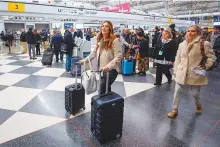  ?? AFP ?? Travellers arrive for their flights at United Airlines Terminal 1 ahead of the Christmas Holiday at O’Hare Internatio­nal Airport yesterday, in Chicago.