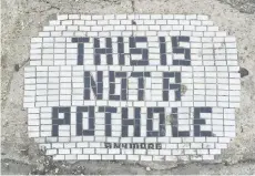  ?? — The Washington Post photos ?? One of Jim Bachor’s creations reads “This is not a pothole anymore.