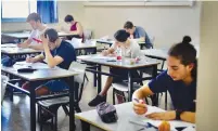  ?? (Avshalom Sassoni/Flash90) ?? KESHET HIGH SCHOOL students take their mathematic­s matriculat­ion examinatio­n yesterday in Tel Aviv.