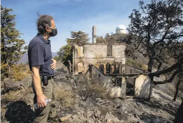  ??  ?? Lick Observator­y Superinten­dent Kostas Chloros surveys the damage at the burnedout 19th century house of Edward Emerson Barnard, one of the 132yearold observator­y’s first astronomer­s.