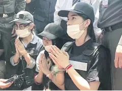  ??  ?? Three female suspects, closely guarded by police during a crime re-enactment, apologise to the family of Warisara Klinjui in Khon Kaen’s Khao Suan Kwang district.