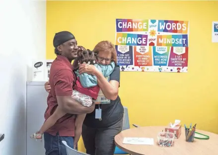  ?? PHOTOS BY GREG LOVETT/PALM BEACH POST ?? Tutor Janice Hamilton hugs Matalia Bush and her dad, Marquis Bush, at The Lord’s Place new 25,000-square-foot client service center at Fortin Family Campus in West Palm Beach. The center celebrated its official opening with a ribbon cutting on Thursday.