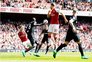  ??  ?? Arsenal’s Spanish defender Nacho Monreal (left) eyes the ball before shooting to score the opening goal during the English Premier League football match between Arsenal and West Ham United at the Emirates Stadium in London. — AFP photo