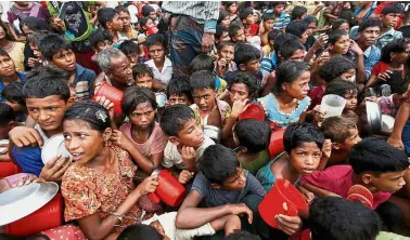  ??  ?? Hungry crowd: Rohingya children waiting to receive food outside the distributi­on centre at Palong Khali refugee camp near Cox’s Bazar, Bangladesh. — Reuters