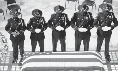  ?? JESSICA MCGOWAN/GETTY IMAGES ?? Members of the Fulton County Sheriff’s Office Honor Guard stand at attention in front of the casket of former U.S. Rep. John Lewis.